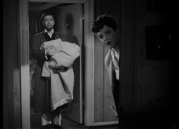 Movie still from “The Talk of the Town” (1942), directed by George Stevens – A man and a woman holding a towel in front of a mirror; Medium shot, Over the shoulder angle