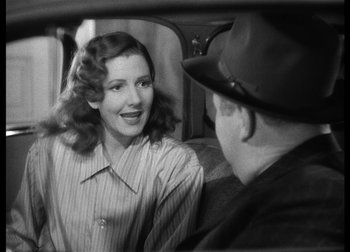 Movie still from “The Talk of the Town” (1942), directed by George Stevens – A woman sitting in a car talking to a man in a hat; Close Up shot, Over the shoulder angle