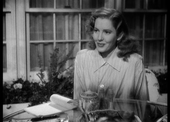 Movie still from “The Talk of the Town” (1942), directed by George Stevens – A woman sitting at a table in front of a window; Close Up shot, Over the shoulder angle