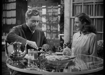 Movie still from “The Talk of the Town” (1942), directed by George Stevens – A man and a woman sitting at a dinner table; Medium shot, Over the shoulder angle