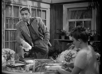 Movie still from “The Talk of the Town” (1942), directed by George Stevens – A black - and - white photo of a man and a woman; Medium shot, Over the shoulder angle