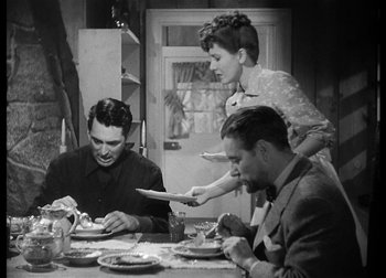 Movie still from “The Talk of the Town” (1942), directed by George Stevens – Three people sitting at a dinner table eating; Medium shot, High angle