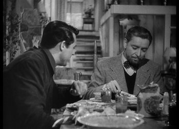 Movie still from “The Talk of the Town” (1942), directed by George Stevens – Two men sitting at a dinner table eating; Medium shot, Over the shoulder angle