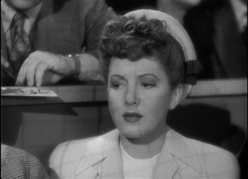 Movie still from “The Talk of the Town” (1942), directed by George Stevens – An old black and white photo of a woman in a nurse's uniform; Close Up shot, Over the shoulder angle