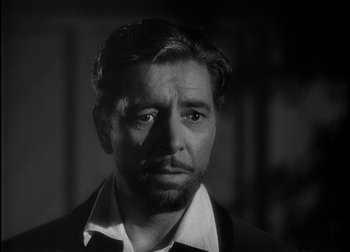 Movie still from “The Talk of the Town” (1942), directed by George Stevens – Black and white photograph of a man in a suit; Close Up shot, Over the shoulder angle