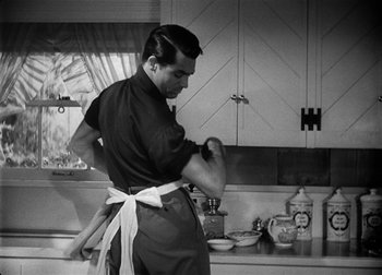 Movie still from “The Talk of the Town” (1942), directed by George Stevens – A black and white photo of a man in the kitchen; Medium shot, Low angle