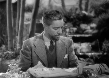 Movie still from “The Talk of the Town” (1942), directed by George Stevens – A black and white photo of a man sitting at a table; Medium shot, High angle