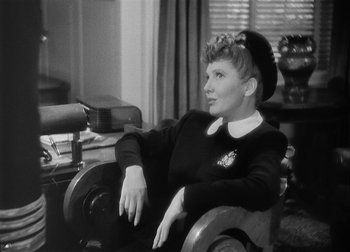 Movie still from “The Talk of the Town” (1942), directed by George Stevens – A woman sitting in a chair in a room; Medium shot, Over the shoulder angle