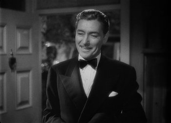 Movie still from “The Talk of the Town” (1942), directed by George Stevens – A man wearing a suit and a bow tie smiling; Close Up shot, High angle