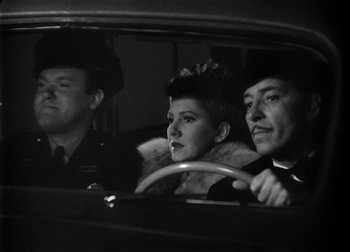 Movie still from “The Talk of the Town” (1942), directed by George Stevens – A man and a woman sitting in the drivers seat of a car; Medium shot, Low angle