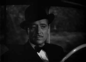 Movie still from “The Talk of the Town” (1942), directed by George Stevens – A black and white photo of a man in a suit and hat; Close Up shot, Over the shoulder angle