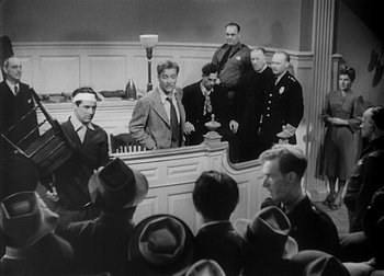 Movie still from “The Talk of the Town” (1942), directed by George Stevens – A black and white photo of men in a courtroom; Medium shot, Over the shoulder angle