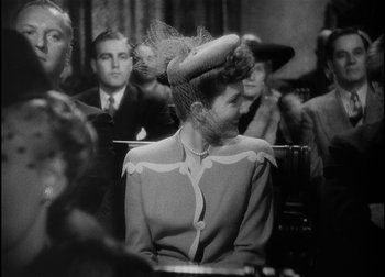 Movie still from “The Talk of the Town” (1942), directed by George Stevens – An old photo of a woman sitting in front of a crowd; Medium shot, Over the shoulder angle