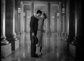 Movie still from “The Talk of the Town” (1942), directed by George Stevens – A man and a woman are kissing in a hallway; Wide shot, Low angle