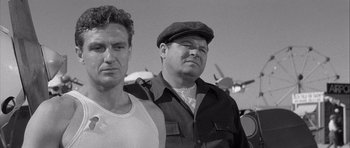Movie still from “The Tarnished Angels” (1957), directed by Douglas Sirk – A black and white photo of two men standing next to each other; Close Up shot, Low angle
