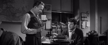 Movie still from “The Tarnished Angels” (1957), directed by Douglas Sirk – Two men are sitting in front of a typewriter; Medium shot, Over the shoulder angle
