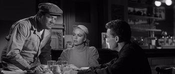 Movie still from “The Tarnished Angels” (1957), directed by Douglas Sirk – A group of people sitting around a table; Medium shot, Over the shoulder angle