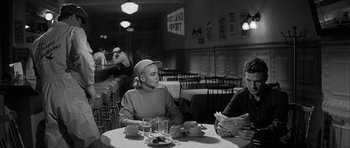 Movie still from “The Tarnished Angels” (1957), directed by Douglas Sirk – A man and woman sitting at a table in a restaurant; Medium shot, Over the shoulder angle