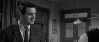 Movie still from “The Tarnished Angels” (1957), directed by Douglas Sirk – A black and white photo of a man in a suit and tie; Close Up shot, Over the shoulder angle