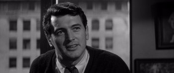 Movie still from “The Tarnished Angels” (1957), directed by Douglas Sirk – Black and white photograph of a man wearing a sweater; Close Up shot, Over the shoulder angle