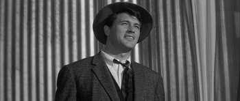 Movie still from “The Tarnished Angels” (1957), directed by Douglas Sirk – A black and white photo of a man wearing a suit and a hat; Close Up shot, Low angle