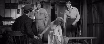 Movie still from “The Tarnished Angels” (1957), directed by Douglas Sirk – An old photo of a woman in a white dress; Medium shot, Low angle