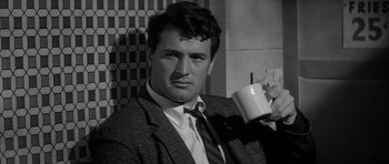 Movie still from “The Tarnished Angels” (1957), directed by Douglas Sirk – A black and white photo of a man holding a coffee mug; Close Up shot, Low angle