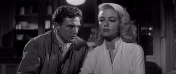 Movie still from “The Tarnished Angels” (1957), directed by Douglas Sirk – A man and a woman standing next to each other; Close Up shot, Low angle