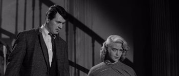 Movie still from “The Tarnished Angels” (1957), directed by Douglas Sirk – A man and a woman standing next to each other; Medium shot, Low angle