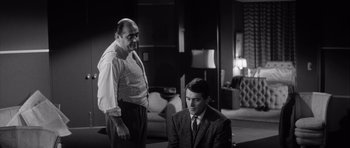 Movie still from “The Tarnished Angels” (1957), directed by Douglas Sirk – Two men in a living room talking to each other; Medium shot, Over the shoulder angle