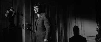 Movie still from “The Tarnished Angels” (1957), directed by Douglas Sirk – A black and white photo of a man in a suit; Medium shot, Low angle