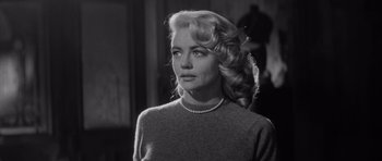 Movie still from “The Tarnished Angels” (1957), directed by Douglas Sirk – A black and white photo of a woman with a pearl necklace; Close Up shot, Low angle