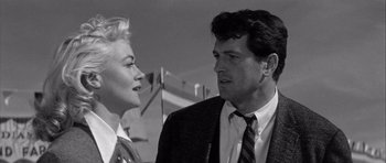 Movie still from “The Tarnished Angels” (1957), directed by Douglas Sirk – A man and a woman standing next to each other; Close Up shot, Low angle