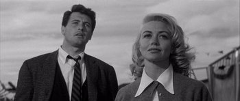 Movie still from “The Tarnished Angels” (1957), directed by Douglas Sirk – A man and a woman standing next to each other; Close Up shot, Low angle