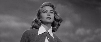 Movie still from “The Tarnished Angels” (1957), directed by Douglas Sirk – A black and white photo of a woman in a suit and tie; Close Up shot, Low angle