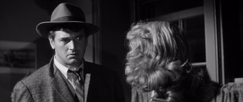 Movie still from “The Tarnished Angels” (1957), directed by Douglas Sirk – A black and white photo of a man and a dog; Close Up shot, Over the shoulder angle