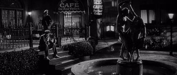 Movie still from “The Tarnished Angels” (1957), directed by Douglas Sirk – A black - and - white photo of a street corner; Wide shot, Low angle
