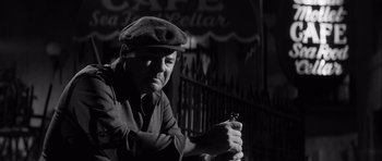 Movie still from “The Tarnished Angels” (1957), directed by Douglas Sirk – A black and white photo of a man holding a lighter; Close Up shot, Low angle