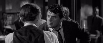 Movie still from “The Tarnished Angels” (1957), directed by Douglas Sirk – A black and white photo of a man in a suit and tie; Close Up shot, Over the shoulder angle