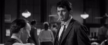 Movie still from “The Tarnished Angels” (1957), directed by Douglas Sirk – A black and white photo of a man smoking a cigarette; Close Up shot, Over the shoulder angle