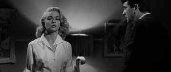 Movie still from “The Tarnished Angels” (1957), directed by Douglas Sirk – A black - and - white photo of a woman in a room; Medium shot, Low angle