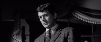 Movie still from “The Tarnished Angels” (1957), directed by Douglas Sirk – Black and white photograph of a man wearing a suit and tie; Close Up shot, Low angle