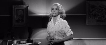 Movie still from “The Tarnished Angels” (1957), directed by Douglas Sirk – A black - and - white photo of a woman holding a wine glass; Medium shot, Low angle