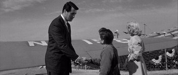 Movie still from “The Tarnished Angels” (1957), directed by Douglas Sirk – A man and a woman shaking hands in front of an airplane; Medium shot, Over the shoulder angle