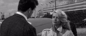 Movie still from “The Tarnished Angels” (1957), directed by Douglas Sirk – A man and a woman are standing next to each other; Close Up shot, Over the shoulder angle