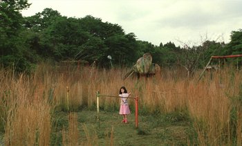 Movie still from “The Taste of Tea” (2004), directed by Katsuhito Ishii – A little girl standing in a field holding a kite; Extreme Wide shot, High angle