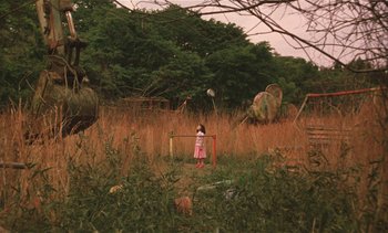 Movie still from “The Taste of Tea” (2004), directed by Katsuhito Ishii – A little girl standing in a field holding a frisbee; Extreme Wide shot, High angle
