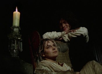 Movie still from “The Tempest” (1979), directed by Derek Jarman – Two women sitting next to each other in front of a lit candle; Medium shot, High angle