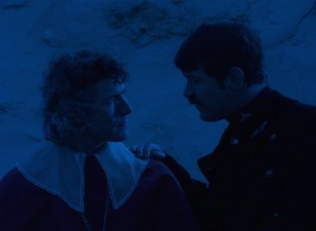 Movie still from “The Tempest” (1979), directed by Derek Jarman – Two men are standing in the dark and one has his hand on the other's shoulder; Close Up shot, Over the shoulder angle