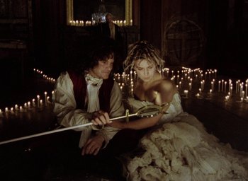 Movie still from “The Tempest” (1979), directed by Derek Jarman – A man and a woman dressed in medieval garb; Medium shot, High angle